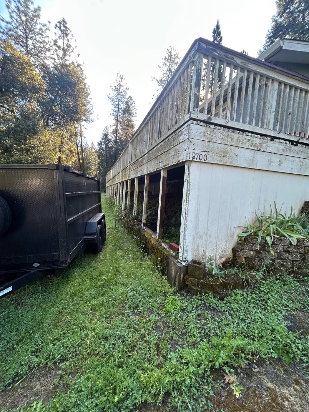 Aging elevated deck with weathered wood railing, before rebuild