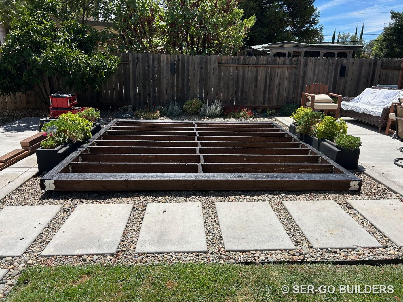 Low backyard deck frame with sealed joists, before decking