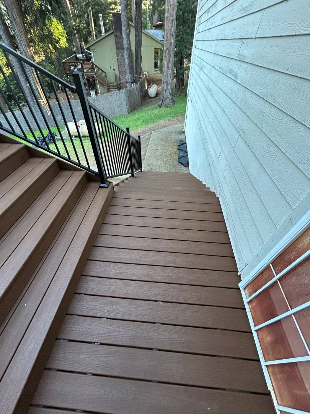 Two-tone composite stairs winding down from a deck