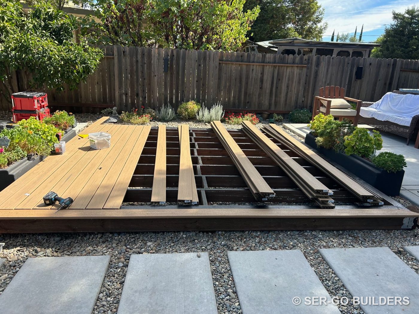 Composite deck boards being fastened over a sealed joist frame
