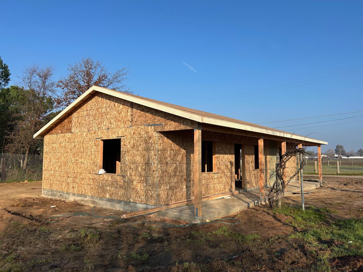 New home sheathed and roofed with a covered front porch