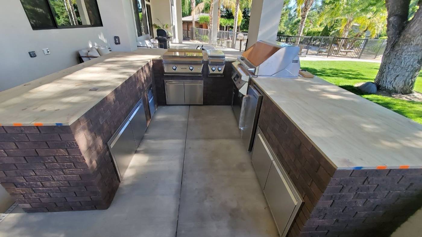 Outdoor kitchen and BBQ island with brick base and concrete counters