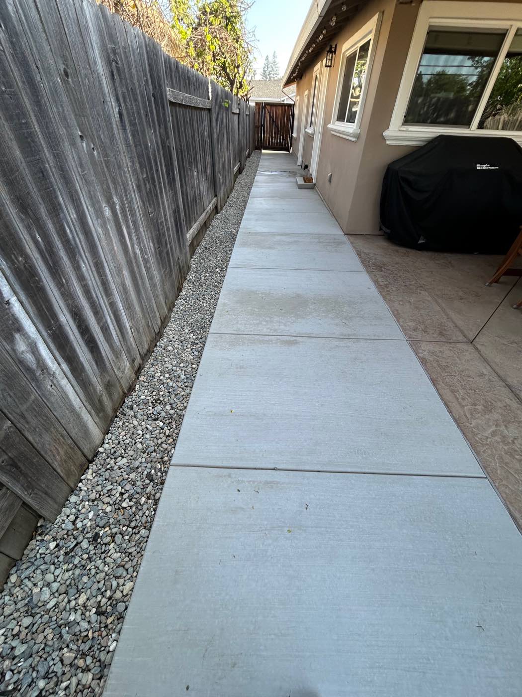 New side-yard concrete walkway with a gravel border