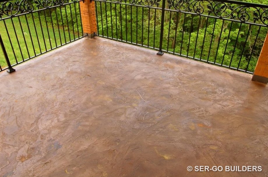 Balcony deck finished with a textured, stained waterproof coating behind a wrought-iron rail