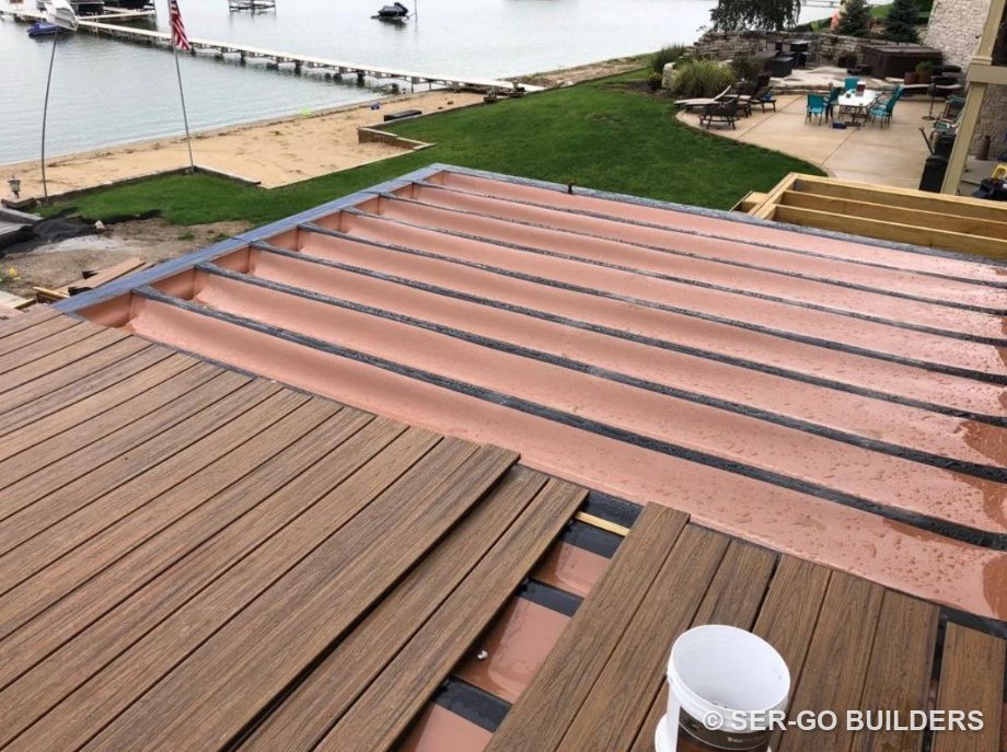 Under-deck drainage membrane over the joists before composite decking goes down